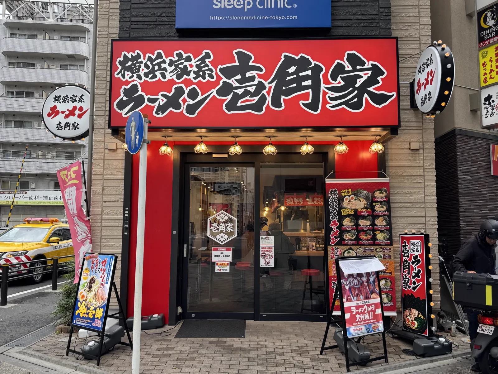 横浜家系ラーメン 壱角家の赤い大型看板 — 都市部の主要駅近くにある家系チェーンの典型例で、ラーメン大盛りキャンペーン中