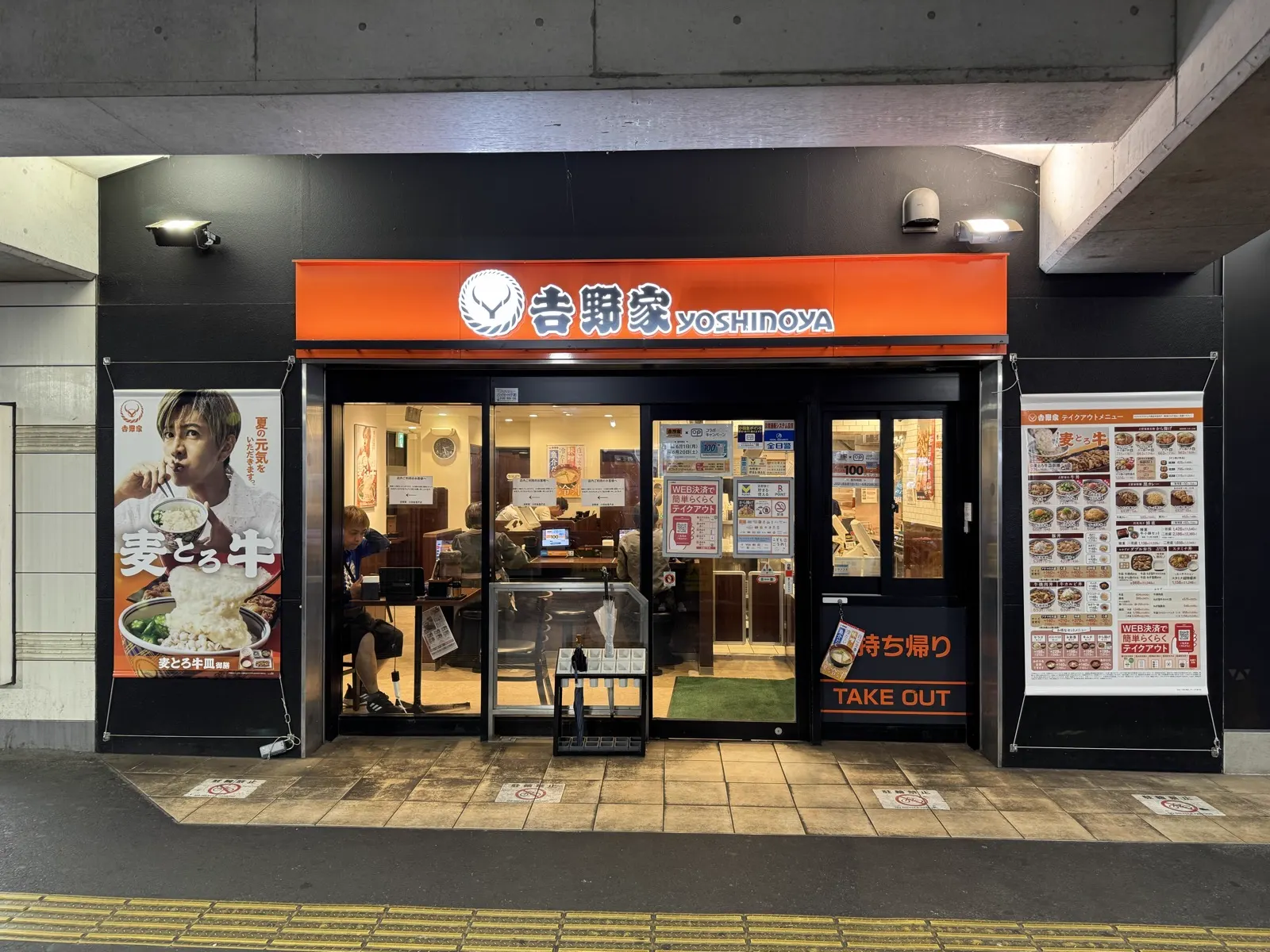 吉野家 駅前店の夜の店構え — 麦とろ牛キャンペーン中・TAKE OUT 対応・テーブル席で女性ひとり客も気軽に入れる雰囲気