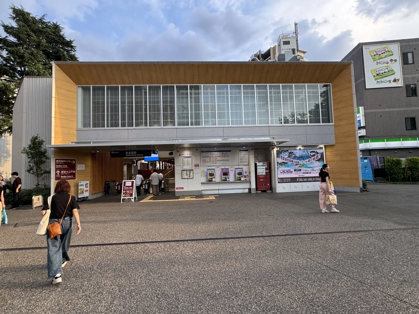 西武豊島線・都営大江戸線「豊島園駅」の駅舎外観 — 券売機とセブン-イレブンが見える改札前広場
