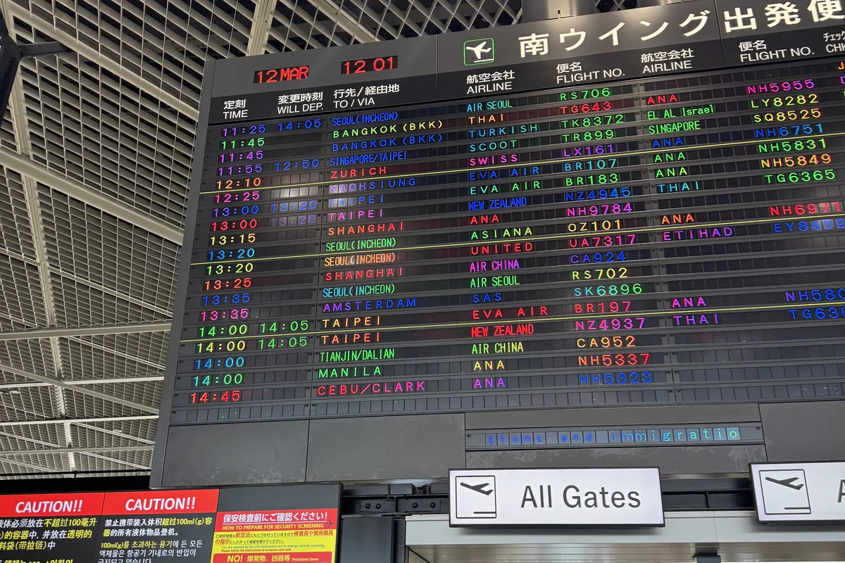 成田空港の出発便案内板 — 両替カウンターを通過する前に確認