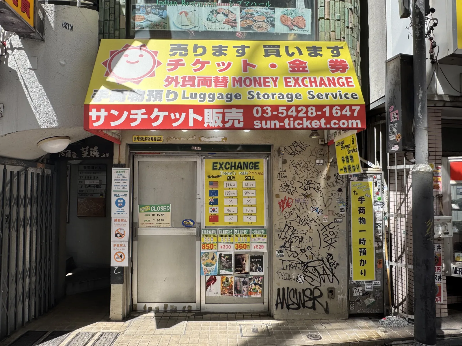 A small ticket-and-currency shop on a Shibuya backstreet advertising MONEY EXCHANGE and luggage storage — convenient but typically 1–2% below the major chains