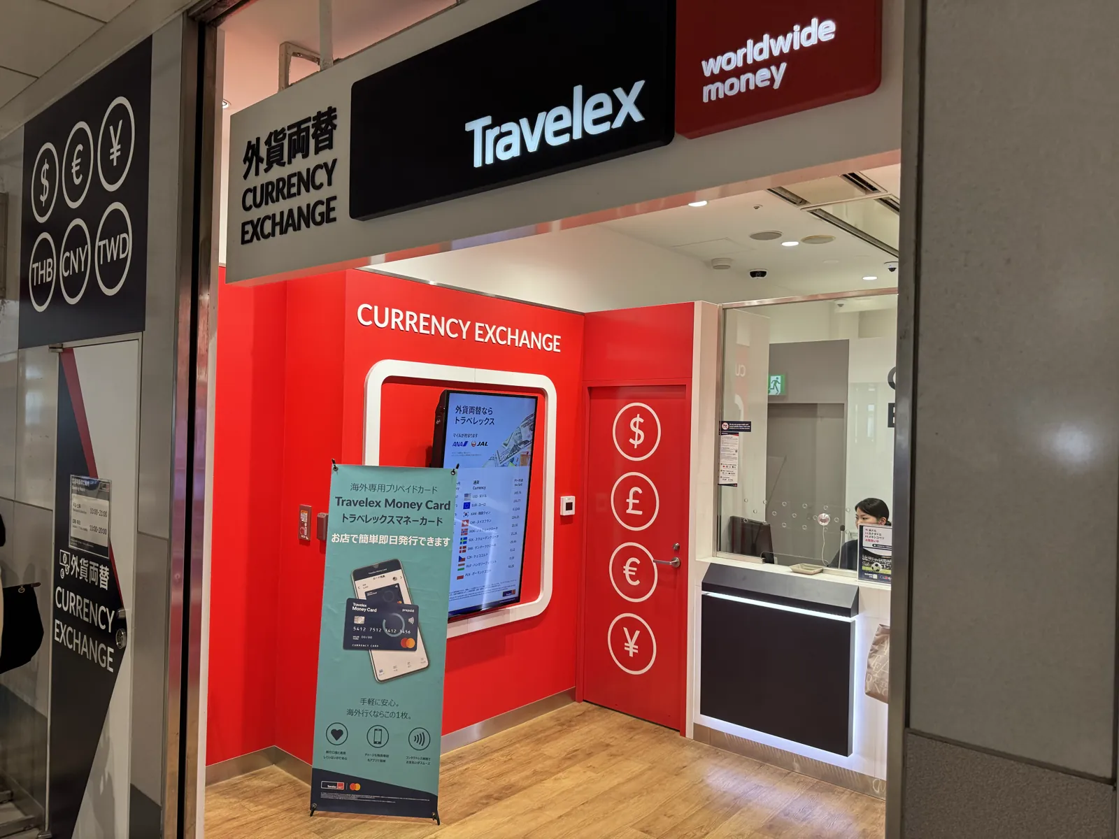 The Travelex counter in Shibuya Mark City — a red-branded worldwide-money booth with USD/GBP/EUR/JPY exchange, a 2-minute walk from the Hachiko Exit