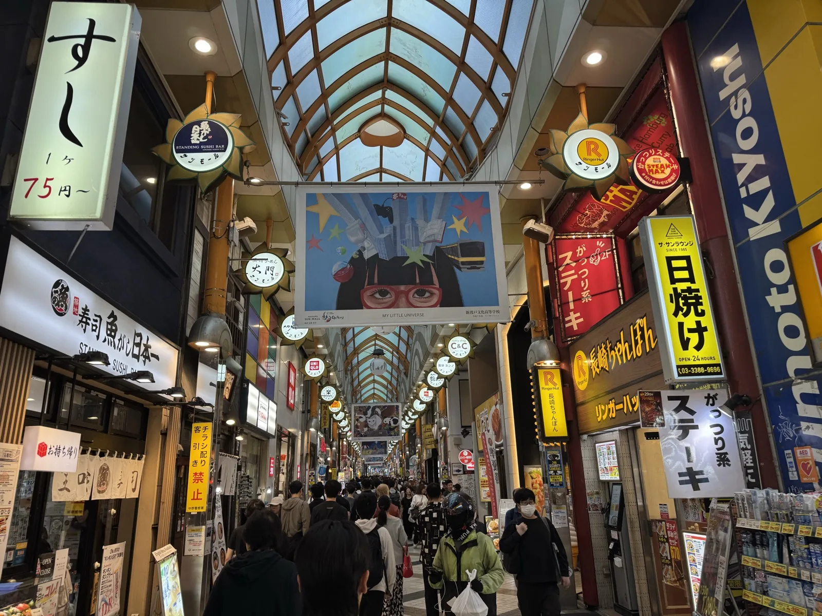 中野サンモール商店街アーケード内、左に寿司看板、右に Mizumoto Kiyoshi 大型壁面ディスプレイ